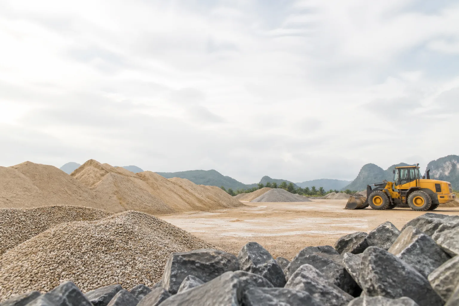Aggregate yard with sand, stones and wheel loader